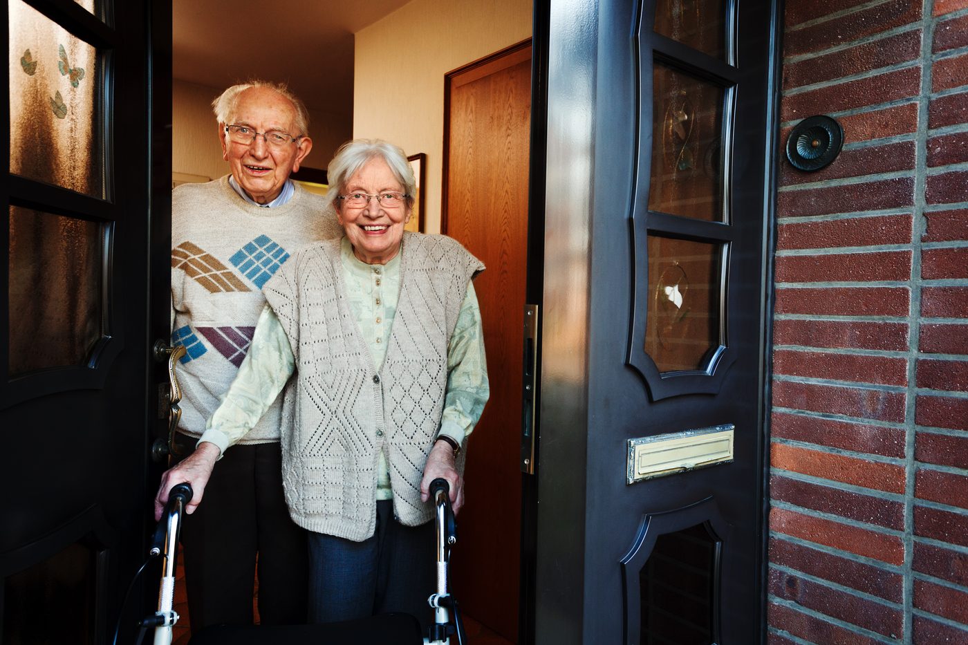An older couple at the front door of their home