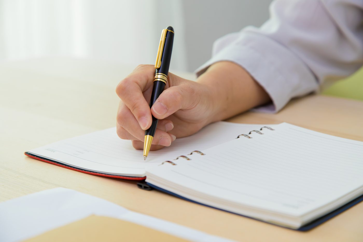 Writing notes with a pen at a desk