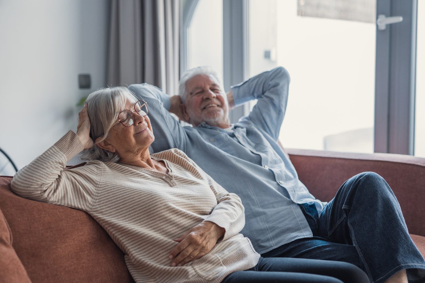 An older couple relaxed on a sofa at home