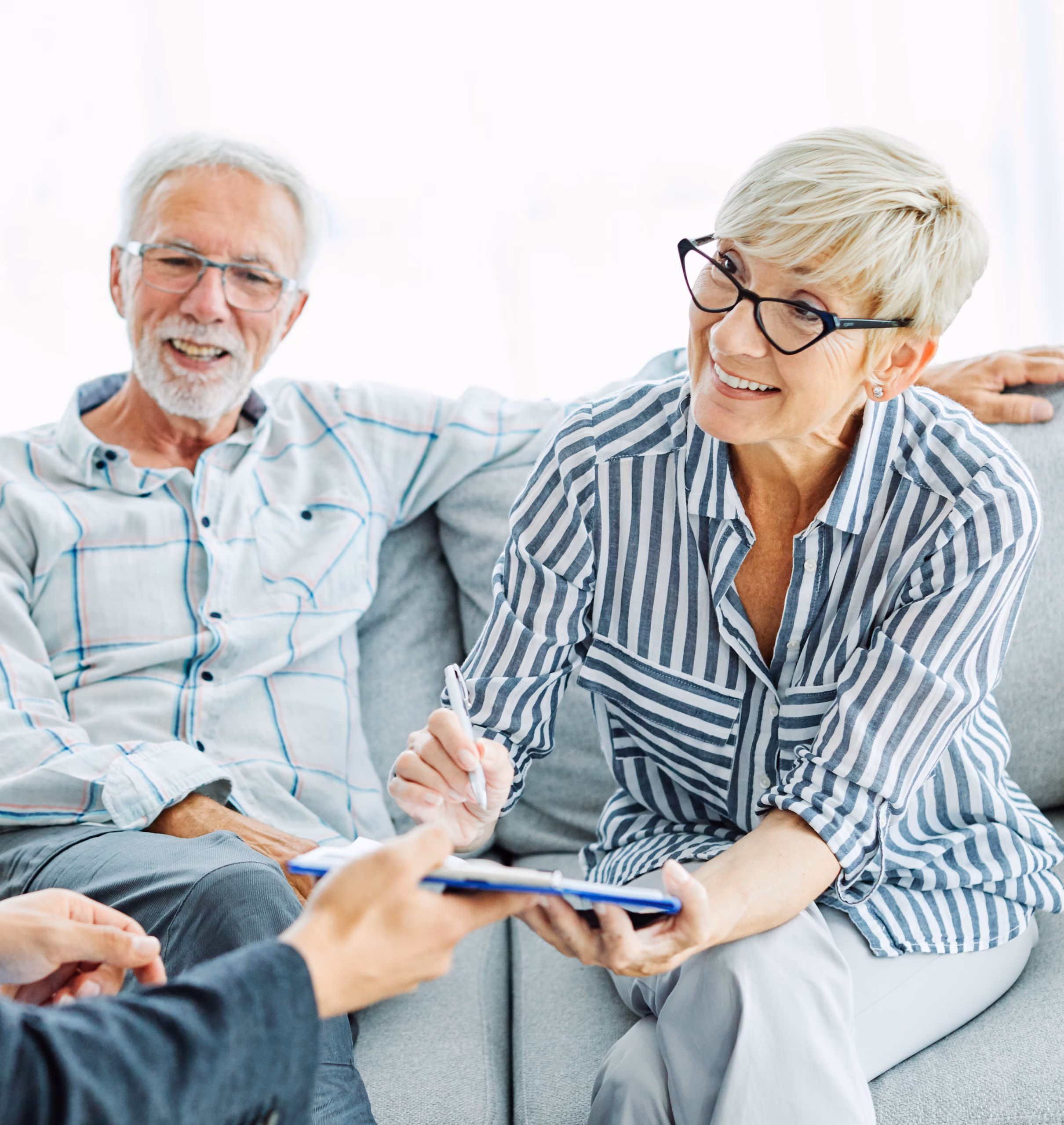 senior couple reviewing documents sofa smiling