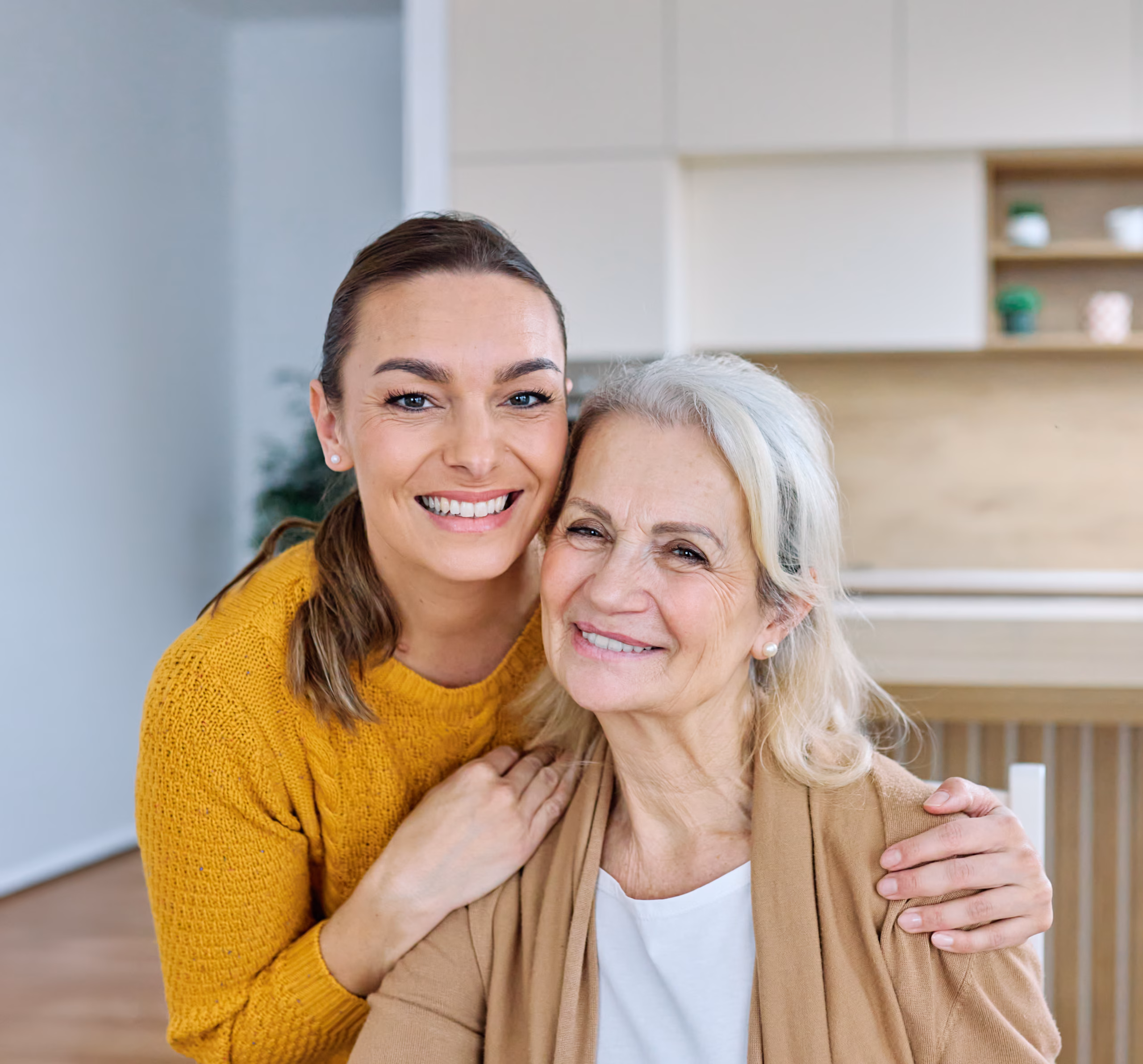 adult daughter hugging elderly mother home